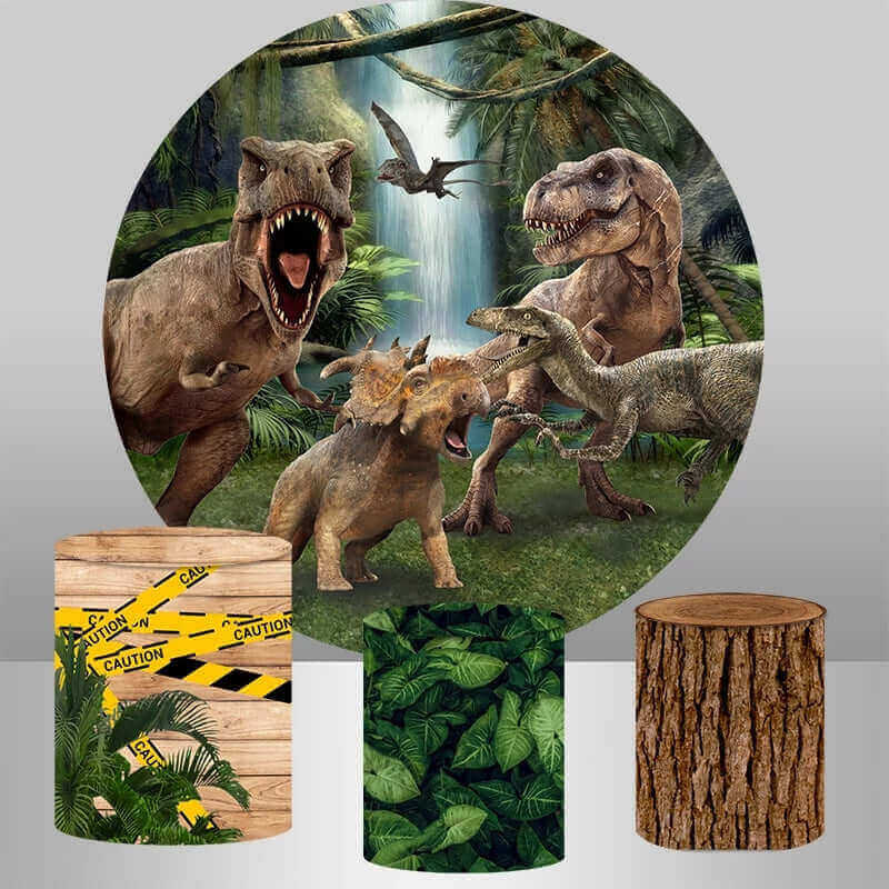 Dinosaur jungle theme round backdrop with a T-Rex, Triceratops, and Velociraptor set in a jungle with a waterfall, complemented by three cylinder covers featuring caution tape, jungle leaves, and tree bark.