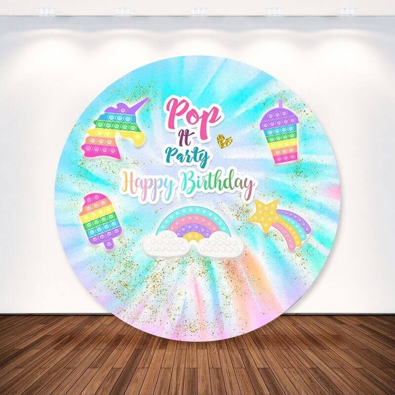 Fun Pop It Happy Birthday round backdrop with vibrant tie-dye design, unicorn, and rainbow accents for birthday décor.