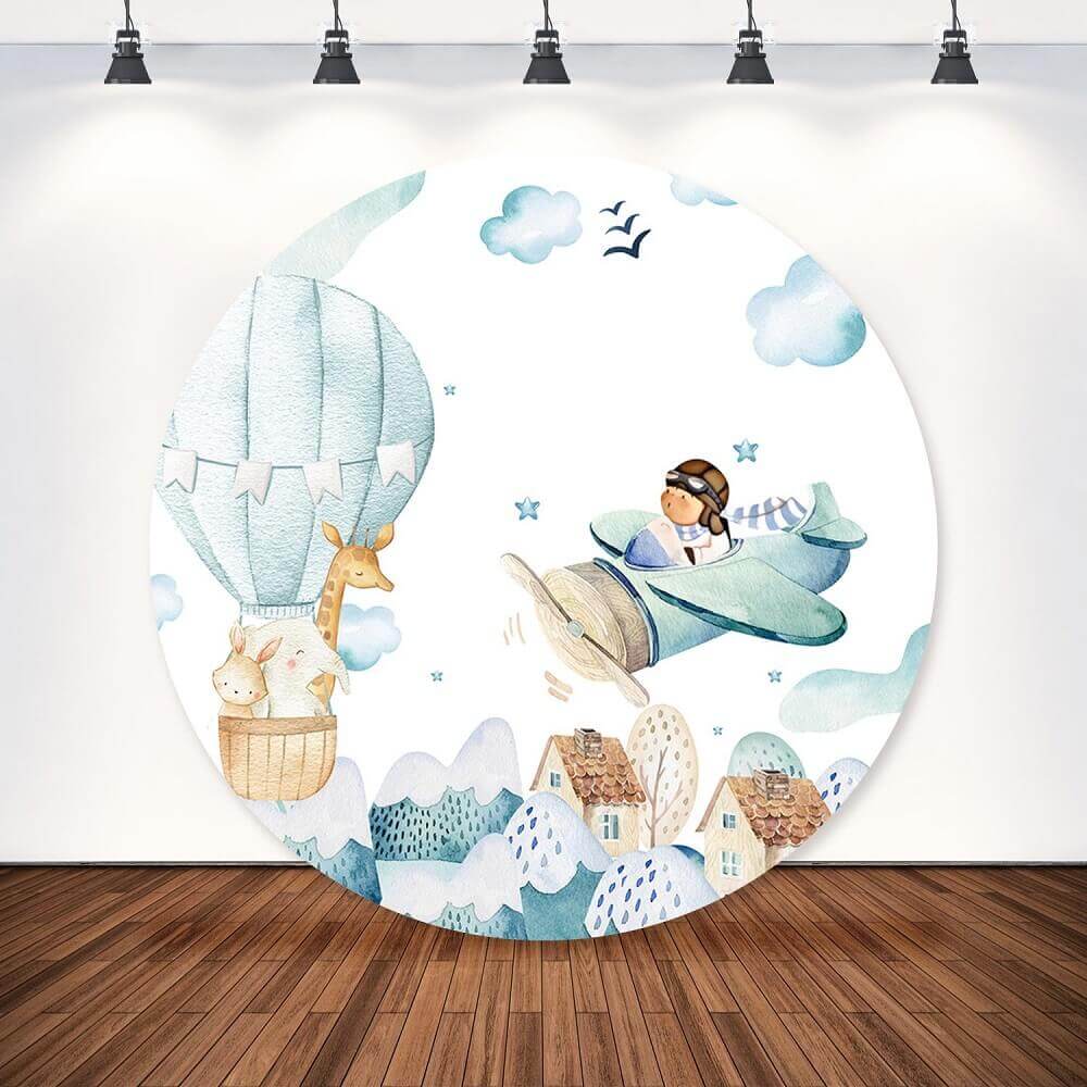 A round backdrop featuring a whimsical design with a pilot in an airplane, a hot air balloon carrying animals, and a scenic sky backdrop perfect for baby showers or kids’ birthday parties.