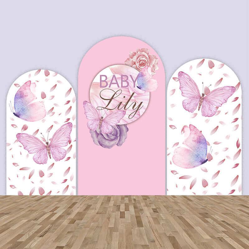 A pink butterfly-themed arched backdrop set featuring three panels: the left and right panels adorned with delicate butterflies and falling petals, and the center panel personalized with "Baby Lily," surrounded by soft roses and watercolor accents. Ideal for baby showers, birthdays, and elegant celebrations.