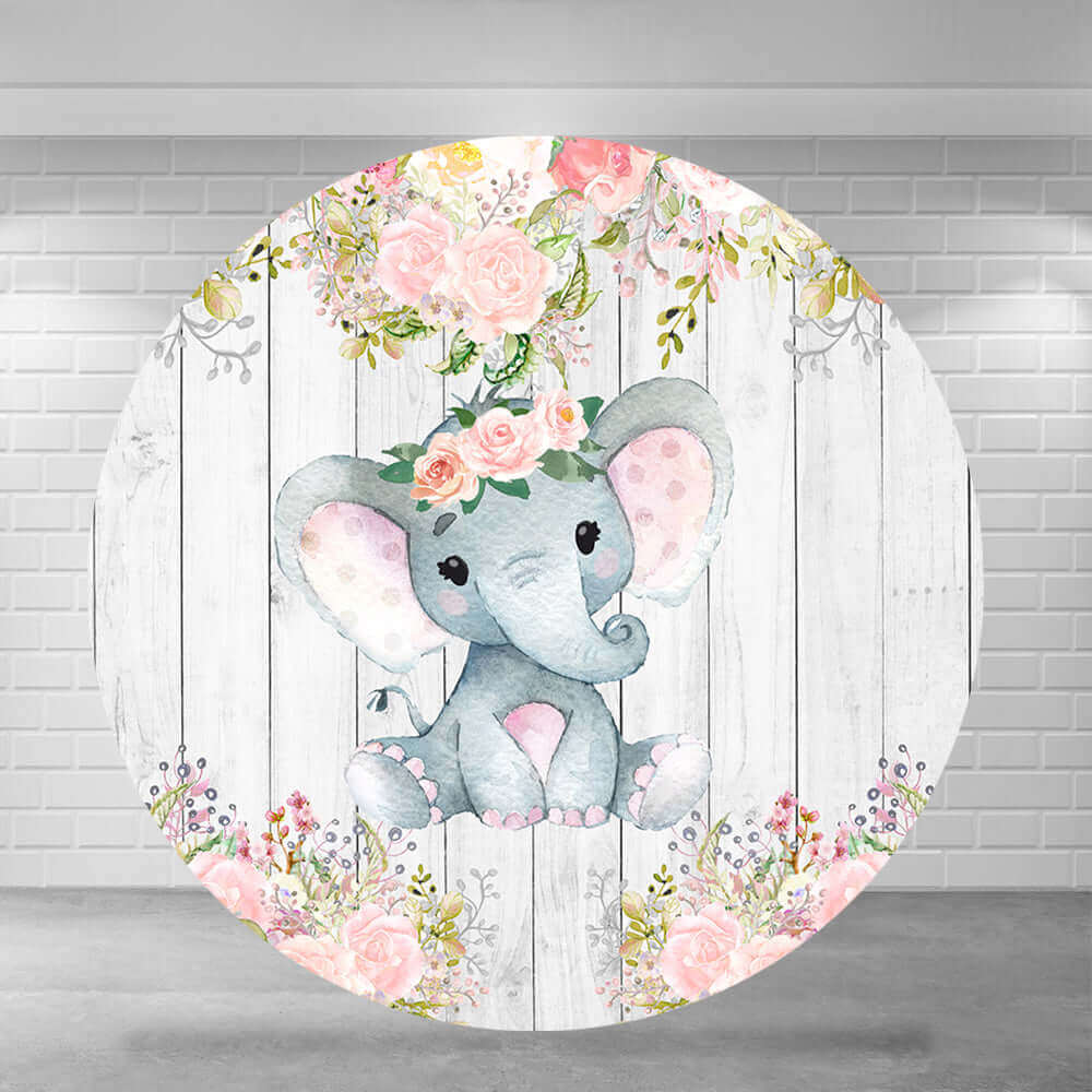 Round baby shower backdrop featuring a cute watercolor elephant with a floral crown, surrounded by pink flowers and a rustic wooden background.