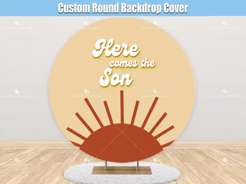 A round backdrop with a retro-inspired 'Here Comes the Son' design featuring a warm sunrise graphic in earthy orange and yellow tones, perfect for baby showers and celebrations.