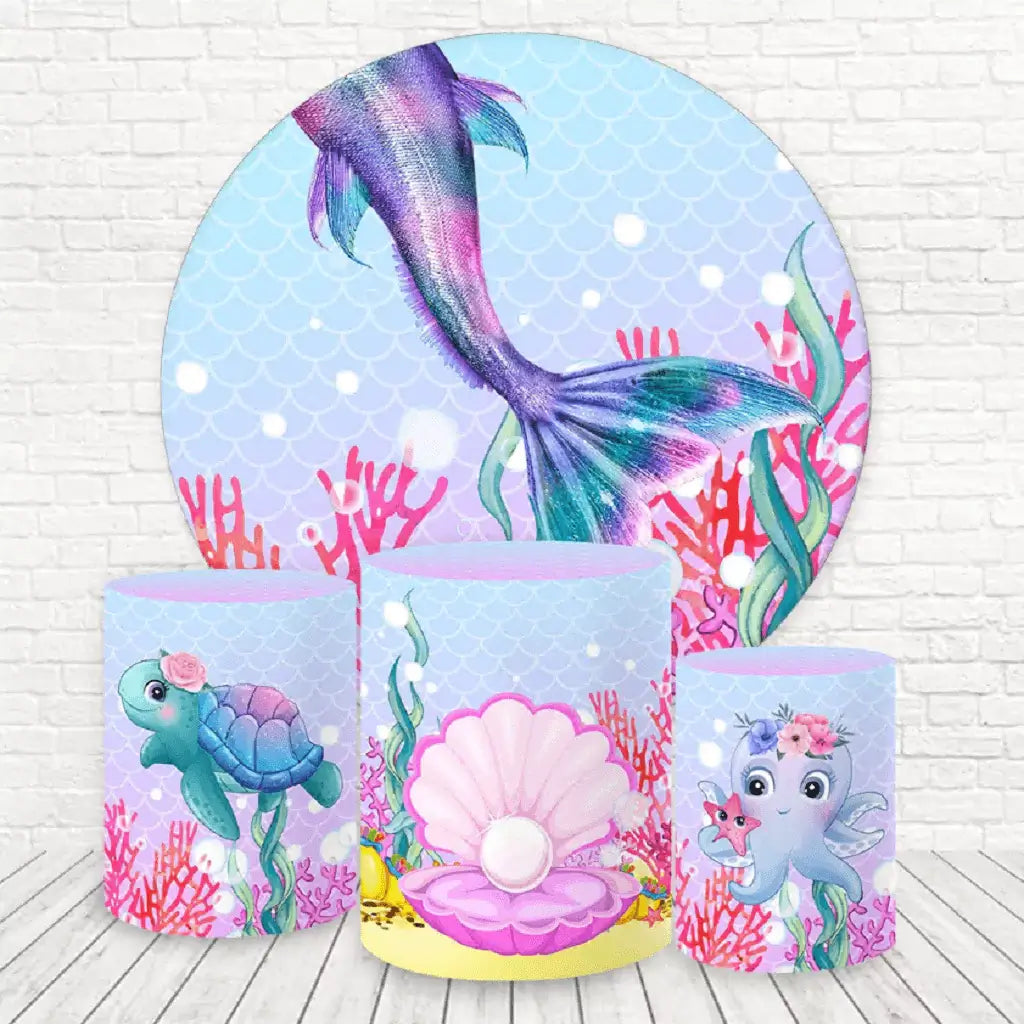 A round mermaid-themed backdrop with a shimmering mermaid tail, surrounded by coral, seaweed, and bubbles, paired with three cylinder covers featuring underwater designs.