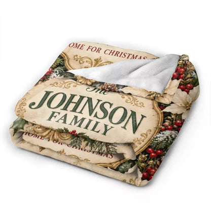 Folded personalized Christmas blanket showing the Johnson family crest, vintage gold artwork, and soft white reverse side.