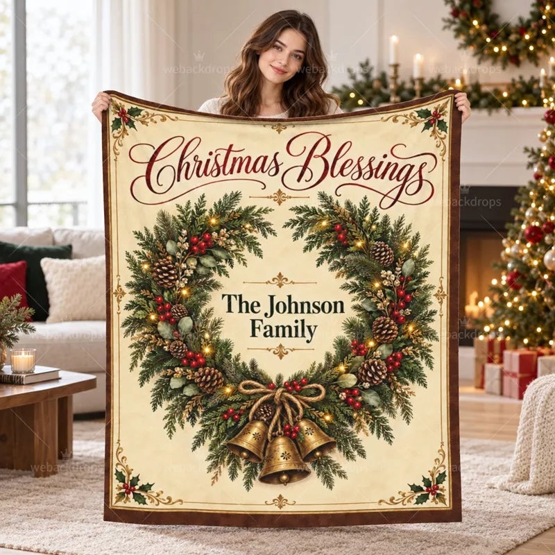 Woman holding a personalized Christmas wreath blanket featuring evergreen cedar branches, golden bells, and The Johnson Family name.