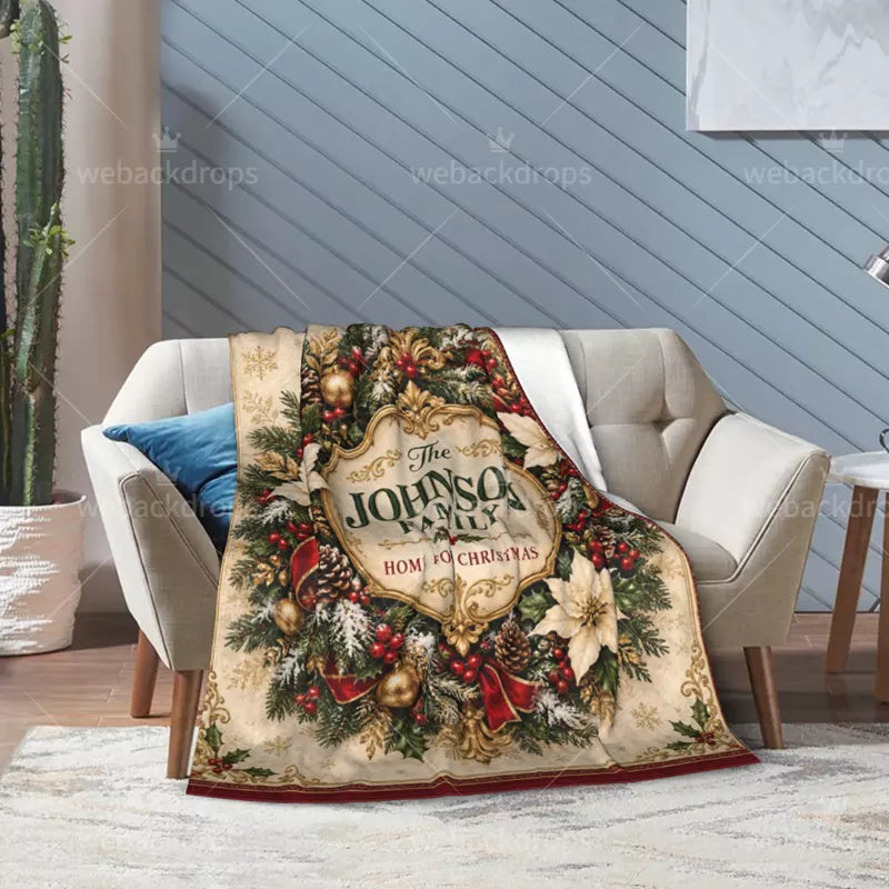 Personalized Christmas flannel blanket displayed across a bed with a vintage family crest, cream poinsettias, and festive greenery.