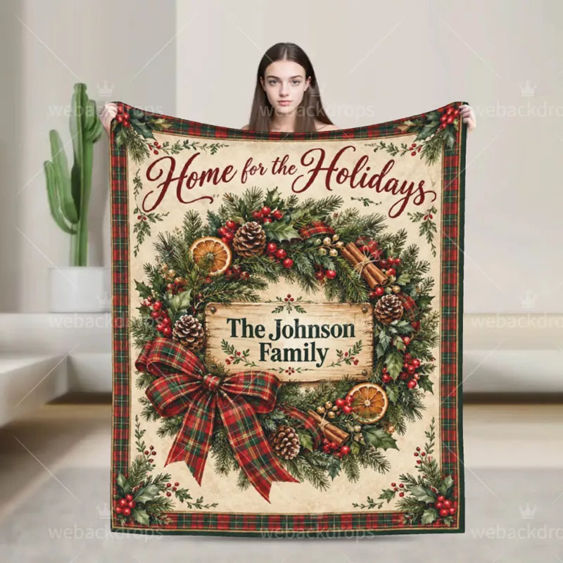 Woman holding a personalized farmhouse Christmas wreath blanket featuring a red and green plaid bow, rustic wooden name sign, and The Johnson Family.
