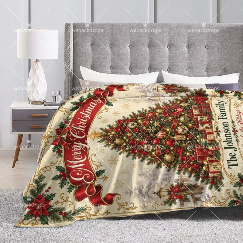 Personalized winter Christmas blanket displayed on a bed, featuring a decorated tree, snowy scenery and custom family name.