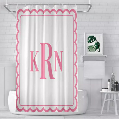 White shower curtain featuring a pink scalloped border, thin inner frame, and large KRN monogram in a modern bathroom.