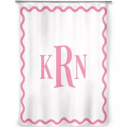 Front view of a white shower curtain featuring a pink wavy border and large KRN monogram, hanging from a silver shower rod.