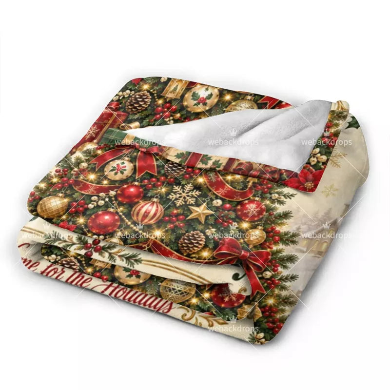 Close-up of a soft fleece personalized Christmas blanket with detailed ornaments, red bows, holiday greenery and custom family print.