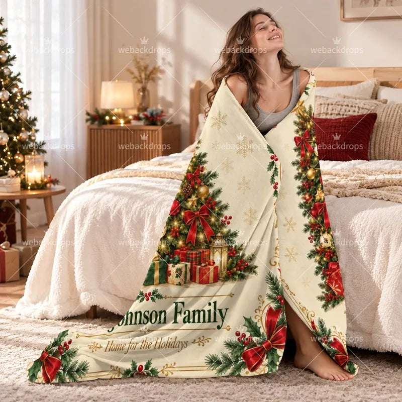 Woman wrapped in a traditional personalized Christmas family blanket with red bows, decorated tree and custom family name.