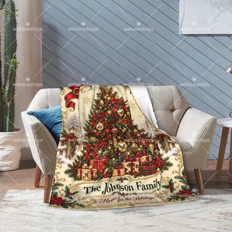 Vintage Christmas tree blanket draped over an armchair with festive ornaments, gifts, poinsettias and personalized family name.