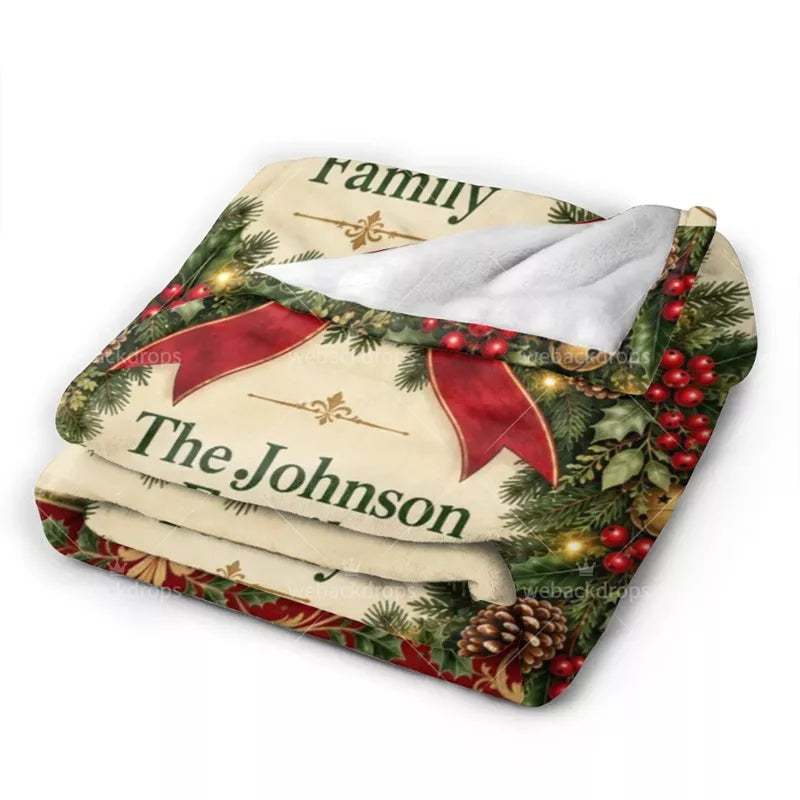 Folded personalized Christmas flannel blanket showing the printed evergreen wreath design and soft white backing.