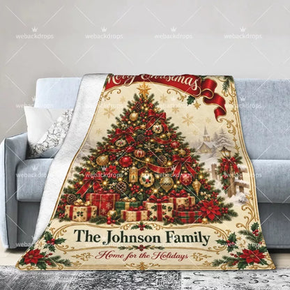 Personalized Christmas throw blanket draped over a sofa with festive tree, gift boxes, winter village and family name design.